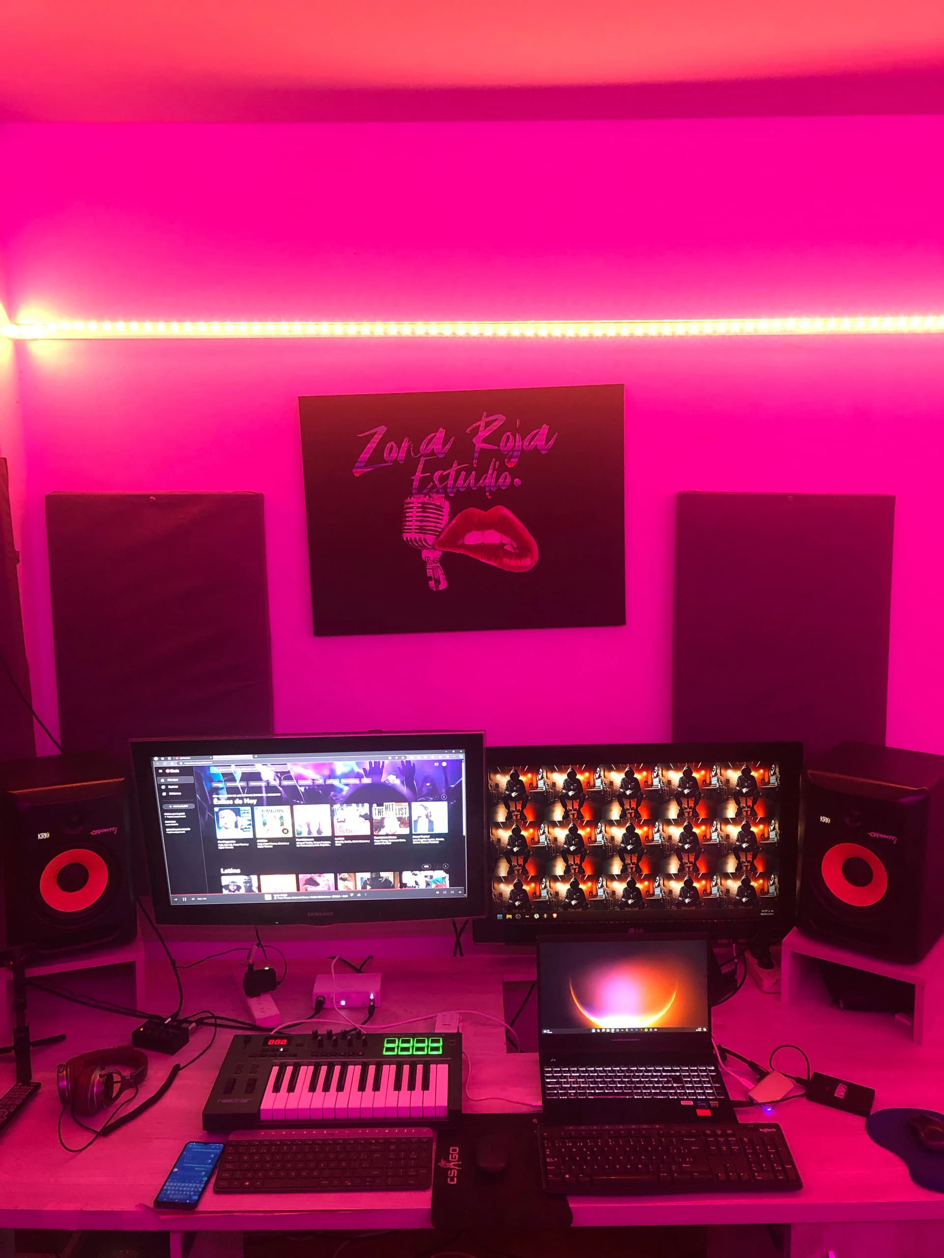 El estudio de Zonarojaestudio iluminado en rosa, con monitores, monitores de audio y controlador MIDI
